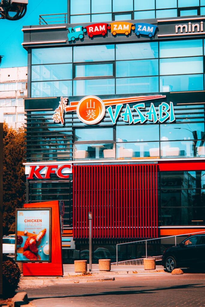 pexels-photo-12906293 Colorful exterior of a fast food building featuring multiple restaurant signs.