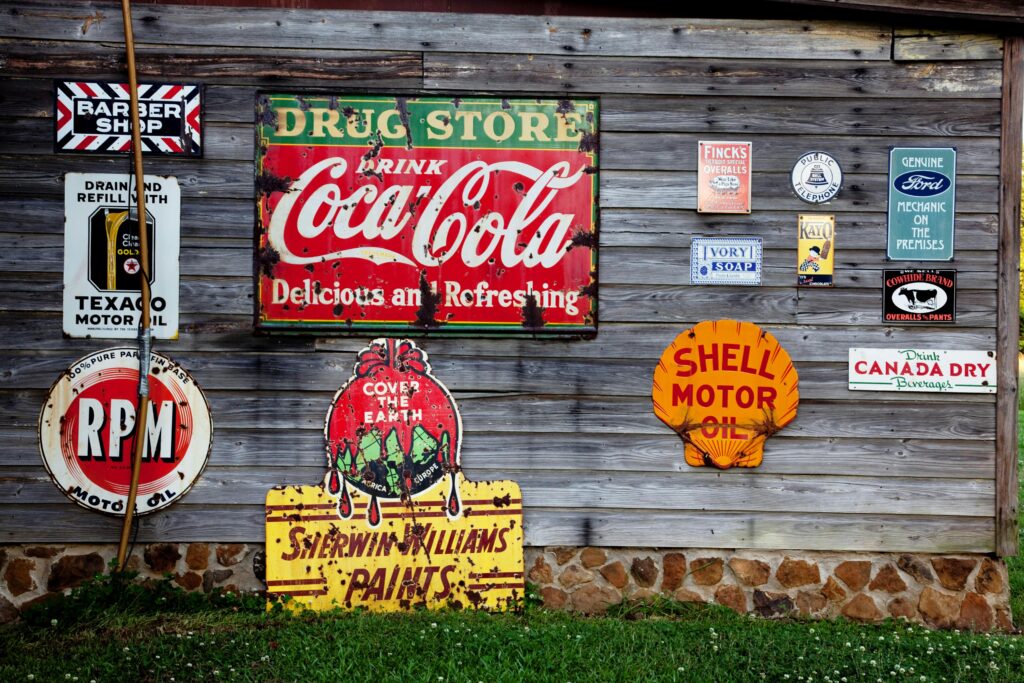 pexels-photo-210126-210126 Collection of vintage advertising signs on rustic wooden wall showcasing classic brands.